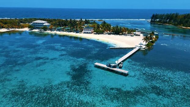 Aerial view of a tropical resort with a wooden pier in Guanaja Honduras.