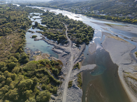 Aerial view of the Buna Drin River Confluence featuring winding river channels gravel banks and lush green vegetation in the rural landscape of Zues Qarku i Shkodres Albania.