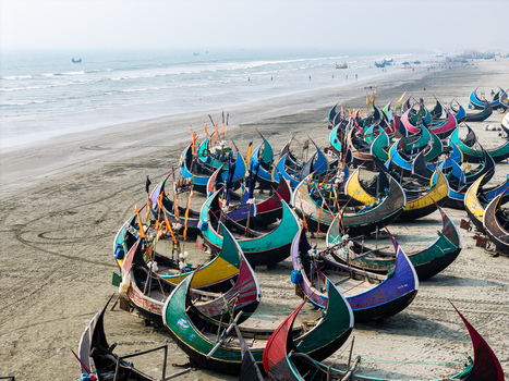 Cox s Bazar Bangladesh 10 March 2026 Aerial view of colorful crescent shaped moon boats parked on the sandy shore of the beach under a hazy sky. Cox s Bazar Bangladesh 10 March 2026 Aerial view of colorful crescent shaped moon boats parked on the sandy shore of the beach under a hazy sky.