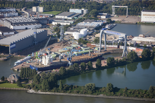 Rotterdam Netherlands 03 September 2014 Aerial view of Rotterdam Harbour with a cargo ship docked at the Damen Shiprepair facility surrounded by industrial cranes and warehouses. Rotterdam Netherlands 03 September 2014 Aerial view of Rotterdam Harbour with a cargo ship docked at the Damen Shiprepair facility surrounded by industrial cranes and warehouses.