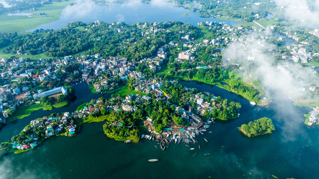 Rangamati Bangladesh 19 October 2022 Aerial view of Rangamati town on Kaptai Lake featuring lush green hills scattered buildings and small boats docked along the waterfront.