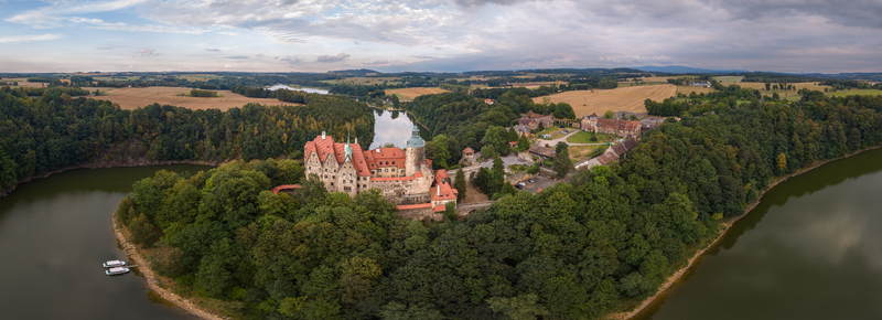 Aerial view of Czocha Castle situated on a forested peninsula surrounded by a river in Sucha Dolnoslaskie Poland during late summer at dusk. Aerial view of Czocha Castle situated on a forested peninsula surrounded by a river in Sucha Dolnoslaskie Poland during late summer at dusk.