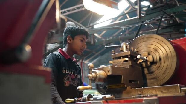 View of a young worker operating a metal lathe Bangladesh.