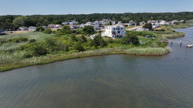 Aerial view of a coastal house situated near a salt marsh and calm water in Westerly Rhode Island United States. Aerial view of a coastal house situated near a salt marsh and calm water in Westerly Rhode Island United States.