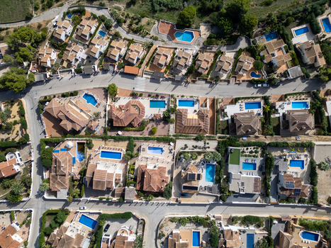 Aerial view of residential villas with private swimming pools and terracotta roofs in Moraira Valencian Community Spain.