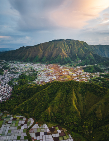 Aerial view of the Sembalun agricultural basin with its patchwork of colorful fields nestled at the foothills of Mount Rinjani in Sembalun West Nusa Tenggara Indonesia. Aerial view of the Sembalun agricultural basin with its patchwork of colorful fields nestled at the foothills of Mount Rinjani in Sembalun West Nusa Tenggara Indonesia.
