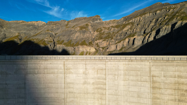 Aerial view of the concrete dam wall at Vieux Emosson Lake set against the rugged mountain landscape of the Swiss Alps in Finhaut Valais Switzerland. Aerial view of the concrete dam wall at Vieux Emosson Lake set against the rugged mountain landscape of the Swiss Alps in Finhaut Valais Switzerland.
