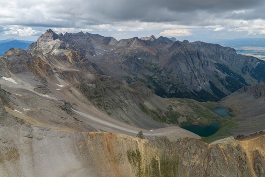 Aerial view of Mount Sneffels and the rugged peaks of the San Juan Mountains featuring the alpine lakes of Yankee Boy Basin and Blue Lakes Pass in Ouray County Colorado United States. Aerial view of Mount Sneffels and the rugged peaks of the San Juan Mountains featuring the alpine lakes of Yankee Boy Basin and Blue Lakes Pass in Ouray County Colorado United States.