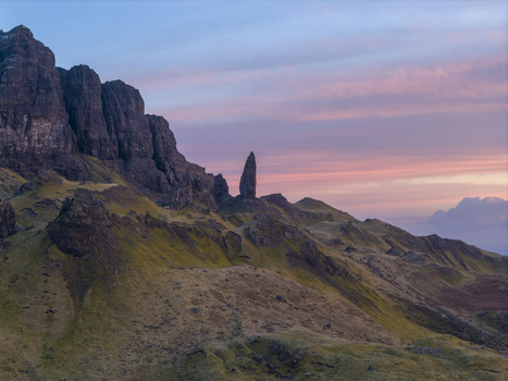 Aerial view of The Storr rock formation with its iconic pinnacle and grassy slopes under a vibrant sunset sky in Isle of Skye Scotland United Kingdom. Aerial view of The Storr rock formation with its iconic pinnacle and grassy slopes under a vibrant sunset sky in Isle of Skye Scotland United Kingdom.