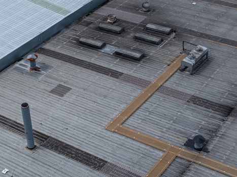 Melbourne VIC Australia 25 September 2026 Aerial view of an industrial rooftop featuring ventilation units metal walkways and chimneys on a corrugated metal surface.