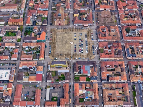 Aerial view of symmetrical streets and red roofed buildings converge on the central plaza creating a harmonious grid Neuf Brisach Grand Est France.