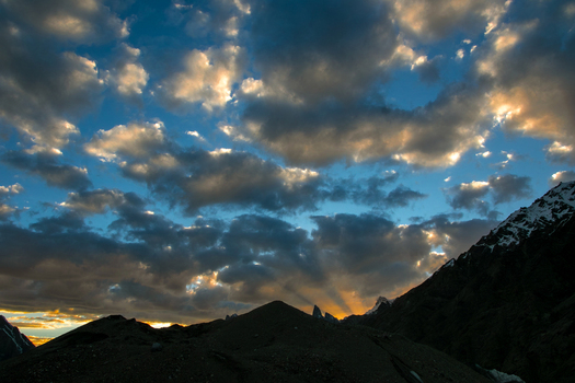 View of Goro II campsite at sunset with dramatic clouds over the Karakoram mountain range in Gilgit Pakistan. View of Goro II campsite at sunset with dramatic clouds over the Karakoram mountain range in Gilgit Pakistan.