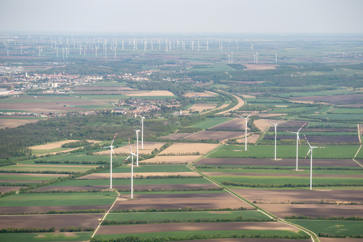 Aerial view of wind turbines standing in vast agricultural fields and green meadows under a clear sky Lower Austria Austria. Aerial view of wind turbines standing in vast agricultural fields and green meadows under a clear sky Lower Austria Austria.