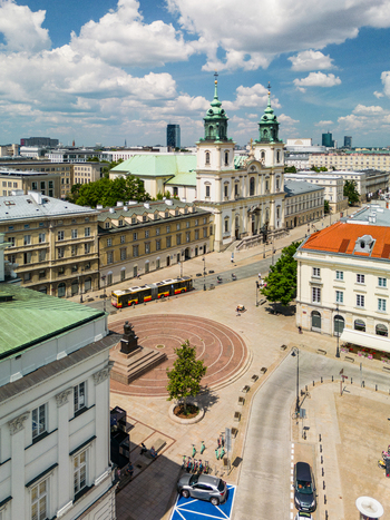 Aerial view of Holy Cross Church and the Nicolaus Copernicus Monument with a city bus and historic buildings in Warsaw Poland. Aerial view of Holy Cross Church and the Nicolaus Copernicus Monument with a city bus and historic buildings in Warsaw Poland.