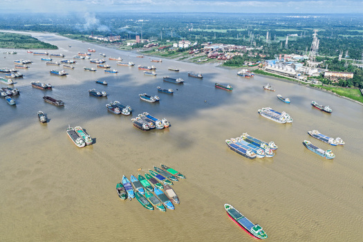 Aerial view of the Karnaphuli River filled with numerous cargo ships and barges docked along the industrial waterfront in Chattogram Chittagong Division Bangladesh.