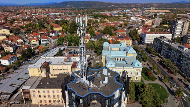 Aerial view of a telecommunications tower on a rooftop historic buildings urban streets and surrounding landscape in Krusevac Rasina District Serbia. Aerial view of a telecommunications tower on a rooftop historic buildings urban streets and surrounding landscape in Krusevac Rasina District Serbia.