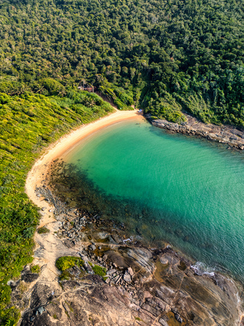 Aerial view of Praia do Ermitao a secluded beach with turquoise waters golden sand and lush green forest surroundings in Guarapari Espirito Santo Brazil. Aerial view of Praia do Ermitao a secluded beach with turquoise waters golden sand and lush green forest surroundings in Guarapari Espirito Santo Brazil.