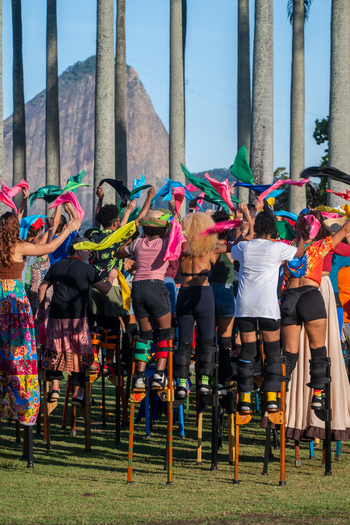 Rio de Janeiro Brazil 20 June 2026 View of Festa Junina performers on stilts waving colorful scarves in a park with palm trees and a mountain in the background. Rio de Janeiro Brazil 20 June 2026 View of Festa Junina performers on stilts waving colorful scarves in a park with palm trees and a mountain in the background.