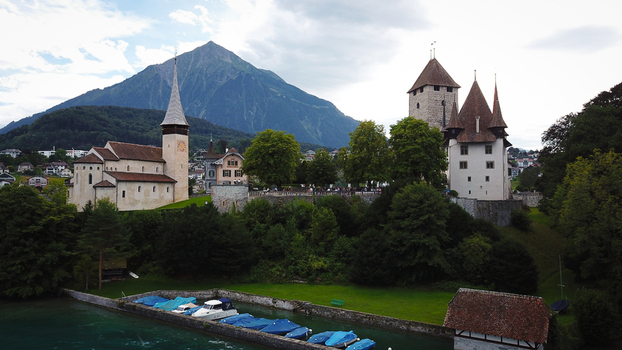 Aerial view of Schloss Spiez and the historic church overlooking Lake Thun with the Niesen mountain peak in Spiez Bern Switzerland. Aerial view of Schloss Spiez and the historic church overlooking Lake Thun with the Niesen mountain peak in Spiez Bern Switzerland.