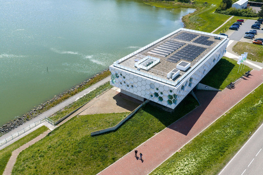 Kornwerderzand Netherlands 14 May 2026 Aerial view of the Afsluitdijk Wadden Center featuring its honeycomb facade and solar panels on the roof next to the water. Kornwerderzand Netherlands 14 May 2026 Aerial view of the Afsluitdijk Wadden Center featuring its honeycomb facade and solar panels on the roof next to the water.