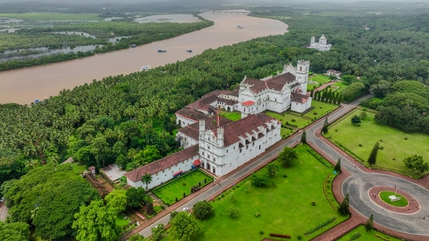 Aerial view of the Church of St. Francis of Assisi surrounded by lush green lawns palm trees and the Mandovi River in Old Goa Goa India. Aerial view of the Church of St. Francis of Assisi surrounded by lush green lawns palm trees and the Mandovi River in Old Goa Goa India.