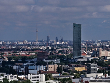 Aerial view of the Estrel Tower skyscraper and the Berlin TV Tower rising above the urban skyline under a cloudy sky in Berlin Berlin Germany. Aerial view of the Estrel Tower skyscraper and the Berlin TV Tower rising above the urban skyline under a cloudy sky in Berlin Berlin Germany.
