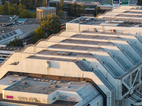 Aerial view of the ICC Berlin a prominent example of Brutalist architecture with its distinctive stepped roof structure and white facade featuring graffiti in Berlin Berlin Germany. Aerial view of the ICC Berlin a prominent example of Brutalist architecture with its distinctive stepped roof structure and white facade featuring graffiti in Berlin Berlin Germany.