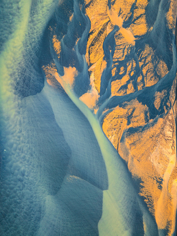 Aerial view of a braided river system featuring intricate patterns of glacial sediment vibrant blue green water and golden brown sandbanks Iceland. Aerial view of a braided river system featuring intricate patterns of glacial sediment vibrant blue green water and golden brown sandbanks Iceland.