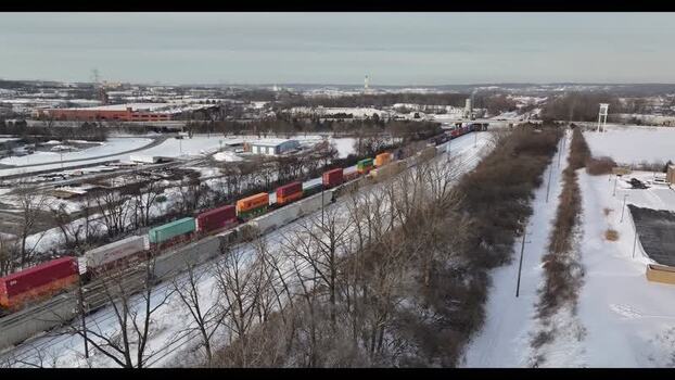 Aerial view of a freight train moving through a snowy landscape United States. Aerial view of a freight train moving through a snowy landscape United States.