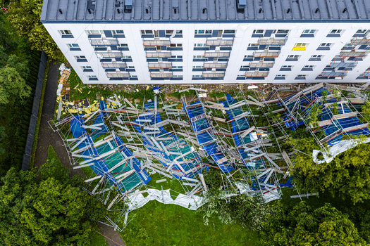 Riga Latvia 23 August 2026 Aerial view of a collapsed scaffolding structure lying on the ground next to a residential apartment building.