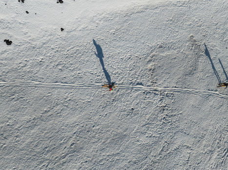 Aerial view of Mount Etna South Slope with a skier casting a long shadow on the white snow and volcanic rocks Nicolosi Sicilia Italy. Aerial view of Mount Etna South Slope with a skier casting a long shadow on the white snow and volcanic rocks Nicolosi Sicilia Italy.