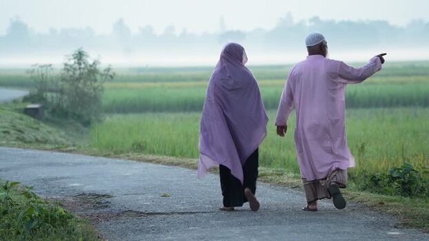 View of an elderly couple walking on a rural road Bangladesh.
