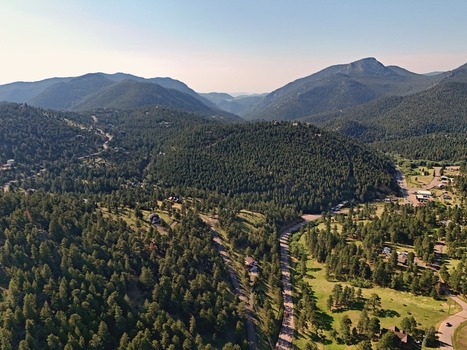 Aerial view of Coal Creek surrounded by dense pine forests rolling hills and winding roads under a clear sky in Coal Creek Colorado United States. Aerial view of Coal Creek surrounded by dense pine forests rolling hills and winding roads under a clear sky in Coal Creek Colorado United States.