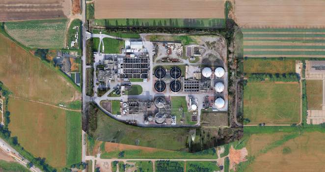 Aerial view of a water treatment facility with circular tanks industrial infrastructure and surrounding agricultural fields in Richmond British Columbia Canada. Aerial view of a water treatment facility with circular tanks industrial infrastructure and surrounding agricultural fields in Richmond British Columbia Canada.