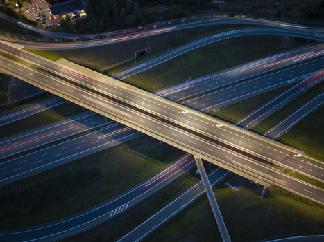 Aerial view of a highway interchange at night with light trails from moving vehicles on the multi level roads illuminated by streetlights in Krakow Lesser Poland Voivode Poland.