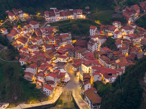 Aerial view of the colorful hillside houses and illuminated streets of the coastal village at dusk in Cudillero Asturias Spain. Aerial view of the colorful hillside houses and illuminated streets of the coastal village at dusk in Cudillero Asturias Spain.