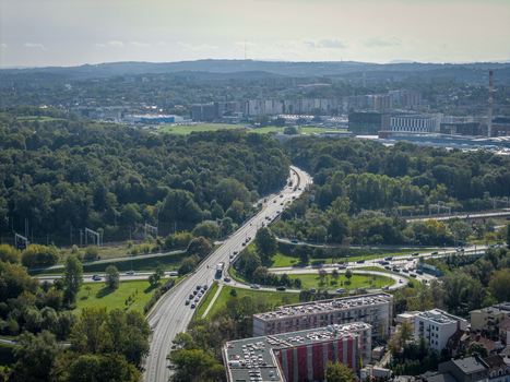 Aerial view of a highway interchange surrounded by lush green trees and urban buildings in Krakow Lesser Poland Voivode Poland.