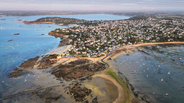 Aerial view of the tranquil bay dotted with sailboats the town s buildings nestled against the rugged coastline a symphony of blues and greens Carantec Bretagne France. Aerial view of the tranquil bay dotted with sailboats the town s buildings nestled against the rugged coastline a symphony of blues and greens Carantec Bretagne France.