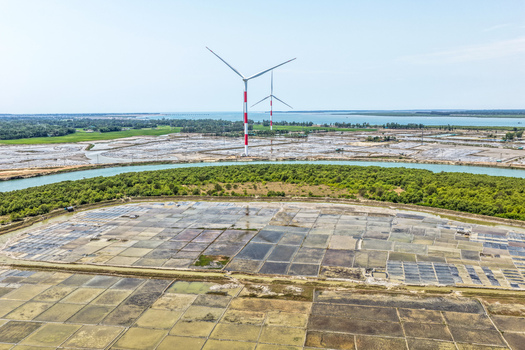 Aerial view of wind turbines standing tall over the patterned landscape near the coast a blend of industry and nature Cox s Bazar Chittagong Division Bangladesh. Aerial view of wind turbines standing tall over the patterned landscape near the coast a blend of industry and nature Cox s Bazar Chittagong Division Bangladesh.