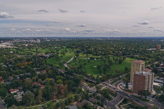 Aerial view of Cherry Creek golf course and surrounding urban landscape with lush trees residential buildings and roads in Denver Colorado United States. Aerial view of Cherry Creek golf course and surrounding urban landscape with lush trees residential buildings and roads in Denver Colorado United States.