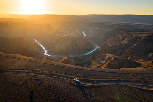 Aerial view of the Fish River Canyon s rugged terrain where golden sunlight bathes the winding river and sculpted cliffs Fish River Canyon Karas Region Namibia. Aerial view of the Fish River Canyon s rugged terrain where golden sunlight bathes the winding river and sculpted cliffs Fish River Canyon Karas Region Namibia.