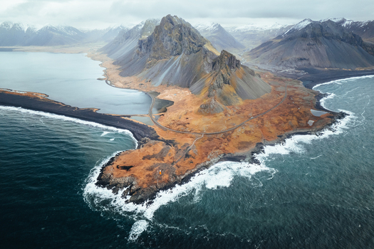 Aerial view of Hvalnes Nature Reserve Beach with the orange lighthouse and dramatic mountain peaks Eystrahorn Sveitarfelagid Hornafjordur Iceland. Aerial view of Hvalnes Nature Reserve Beach with the orange lighthouse and dramatic mountain peaks Eystrahorn Sveitarfelagid Hornafjordur Iceland.