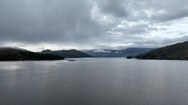 Aerial view of Corani Lake surrounded by rolling hills under a cloudy sky in Chapare Cochabamba Department Bolivia.
