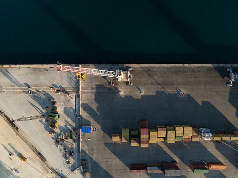 Aerial view of the Port of Augusta with a large industrial crane and colorful shipping containers on the pier Augusta Sicily Italy. Aerial view of the Port of Augusta with a large industrial crane and colorful shipping containers on the pier Augusta Sicily Italy.