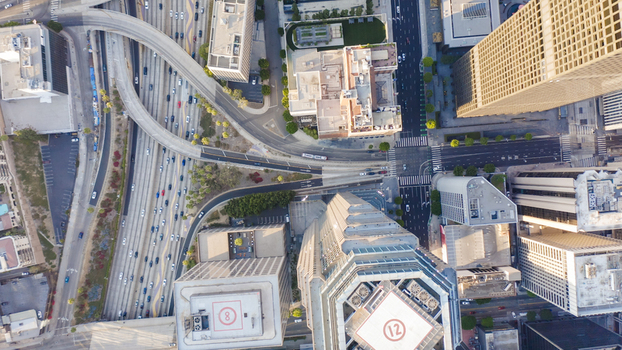 Aerial view of downtown Los Angeles skyline featuring high rise buildings busy highway interchanges and urban streets during the golden hour Los Angeles California United States.