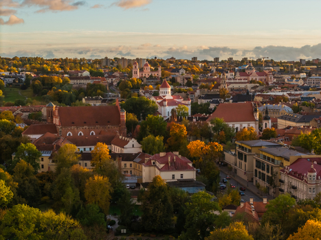 Aerial view of the historic Vilnius cityscape where terracotta roofs meet verdant trees under a soft sky revealing the architectural tapestry of the city Vilnius Lithuania. Aerial view of the historic Vilnius cityscape where terracotta roofs meet verdant trees under a soft sky revealing the architectural tapestry of the city Vilnius Lithuania.