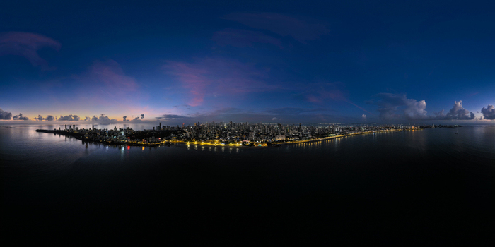 Aerial view of the illuminated Marine Drive promenade and the coastal skyline under a twilight sky in Mumbai Maharashtra India.