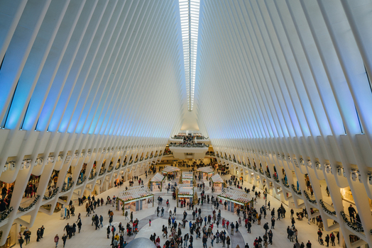 View of the Oculus transportation hub with its white ribbed structure and high skylight bustling with people walking through the modern interior in New York New York United States.