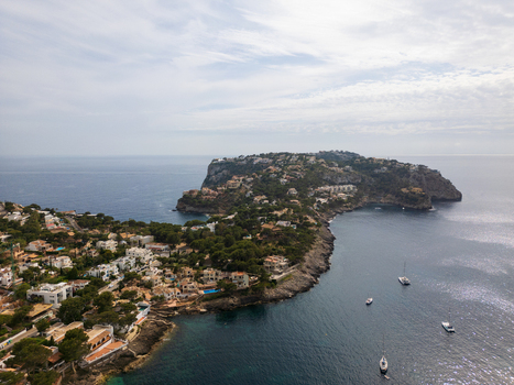 Aerial view of the coastal town of Port d Andratx with white villas on rocky cliffs overlooking the Mediterranean Sea and anchored boats Port d Andratx Balearic Islands Spain. Aerial view of the coastal town of Port d Andratx with white villas on rocky cliffs overlooking the Mediterranean Sea and anchored boats Port d Andratx Balearic Islands Spain.