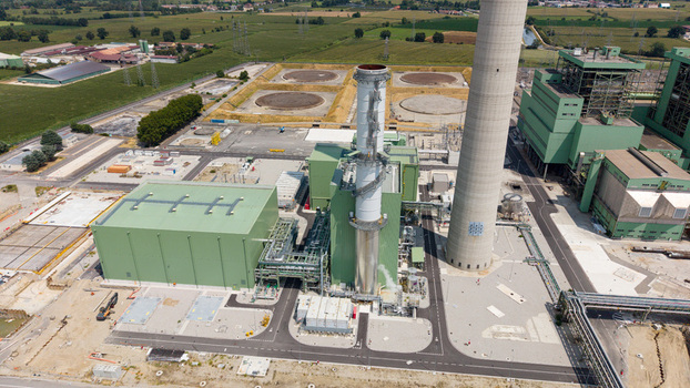Aerial view of a modern combined cycle natural gas power station with a tall chimney and industrial infrastructure in Tavazzano con Villavesco Lombardy Italy.